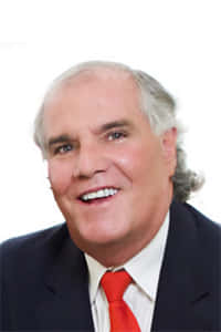 Michael D. Sullivan, a professional real estate broker at Halls Associates, dressed in a formal suit and tie, posing confidently against a neutral background.